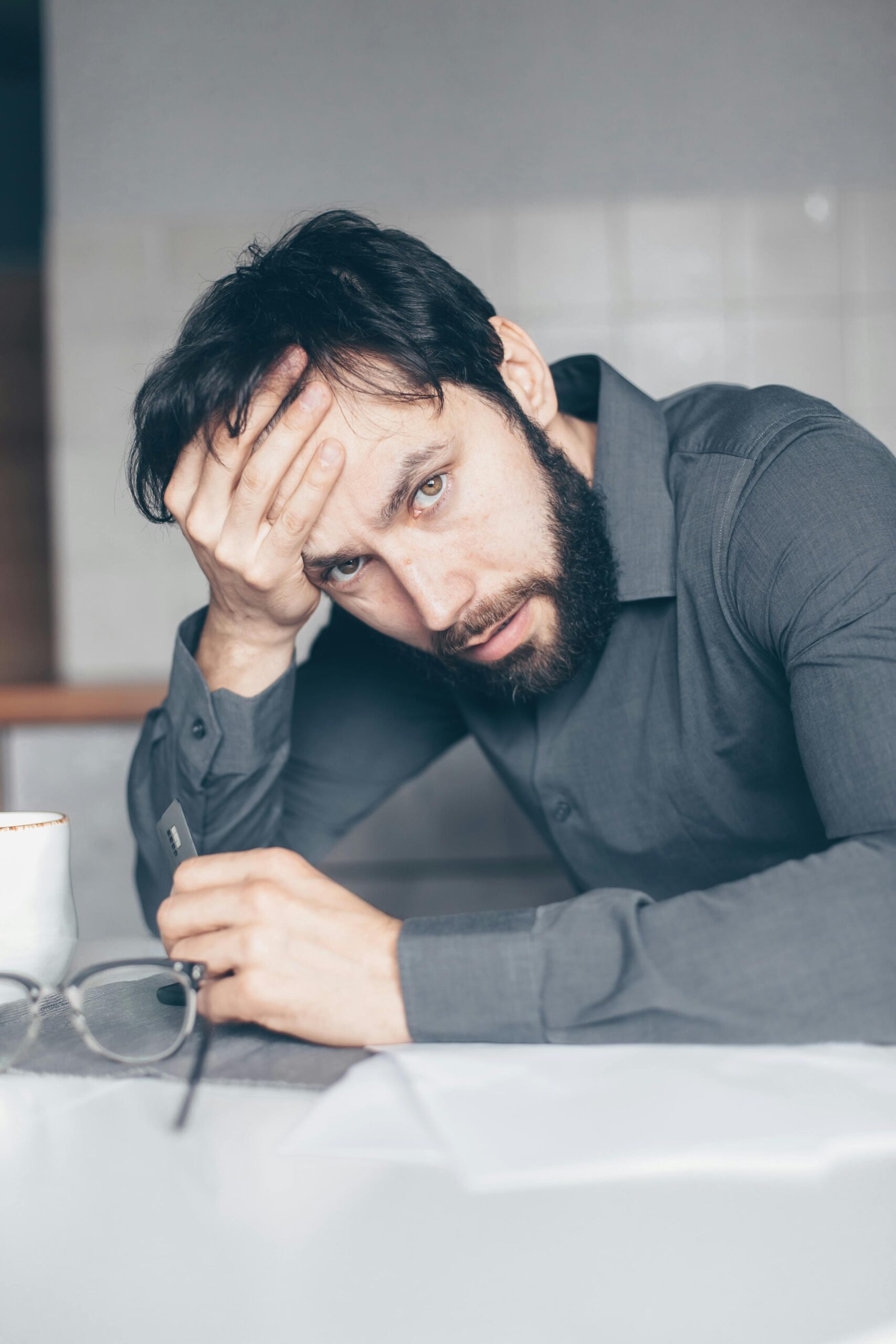 A person holding a credit card, looking concerned, wondering, can you go to jail for disputing charges?